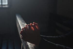 Person Holding Hands in Prayer