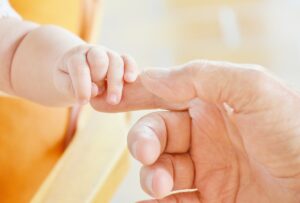 Adult holding baby hand