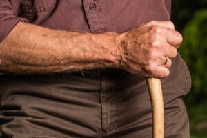 Man Holding a Wooden Cane